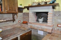 Particolare di cucina in muratura con forno a legna