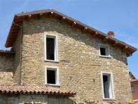 Un esempio di fabbricato ristrutturato con tetto in legno e muro a sassi a facciavista